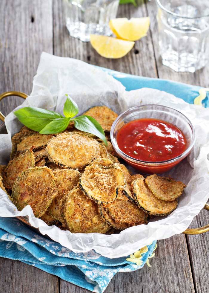 Fotografia in primopiano delle chips di zucchine, antipasto vegetariano